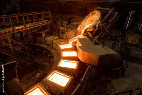 Tank pours liquid metal in the molds by carousel machine photo