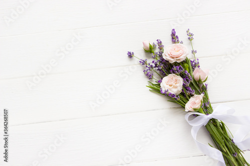 Bunch of Lavender flowers and pink roses  flat lay   mock up  provence template  lavender template for greeting cards with copy space  wedding layout   white wooden board  wedding desk