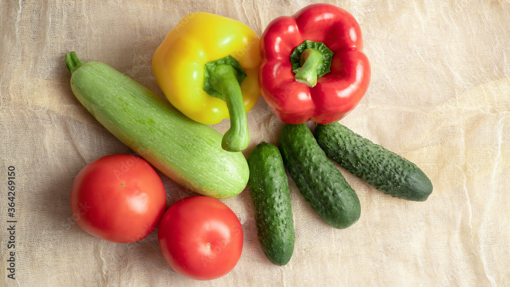 Summer set of vegetables. Ripe yellow and red bell peppers, cucumbers, tomatoes, zucchini. Soft fabric