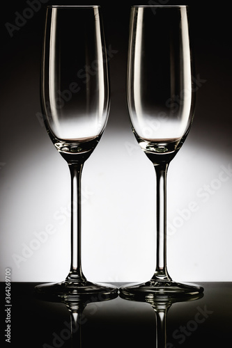 Two champagne glasses studio dark reflection
