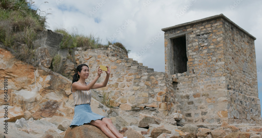 Woman take photo on cellphone at tourist attraction