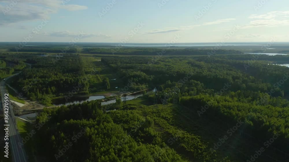 series panoramic views from the height of bird flight on the evening route , with a bridge across the river. Cargo traffic on the Expressway in the middle of the forest at sunset. series panoramic views from the height of bird flight on the evening route , with a bridge across the river. Cargo traffic on the Expressway in the middle of the forest at sunset.