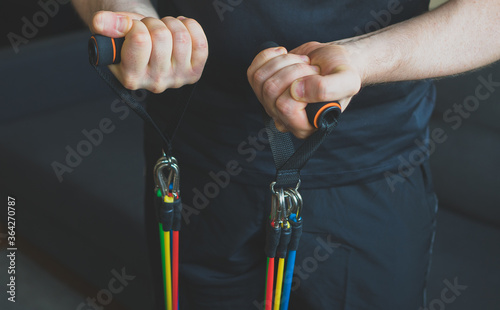 Fotografia Man doing exercises with resistance bands at home.