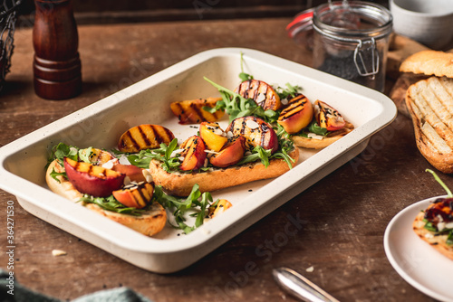Grilled vegetarian baguette sandwiches with arugula, grilled peach, black sesame and almond