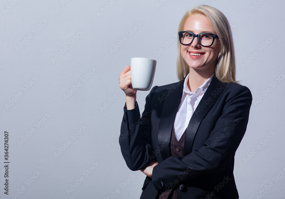 Beautiful blonde businesswoman in suit with cup of coffee Beautiful blonde businesswoman in suit with cup of coffee