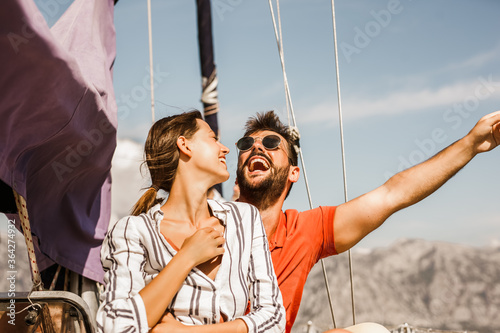 Loving couple spending happy time on a yacht at sea. Luxury vacation on a seaboat. photo