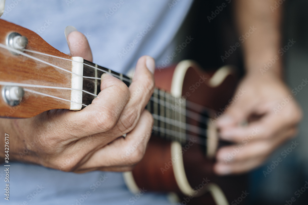 Fototapeta premium Close up Young man playing ukulele