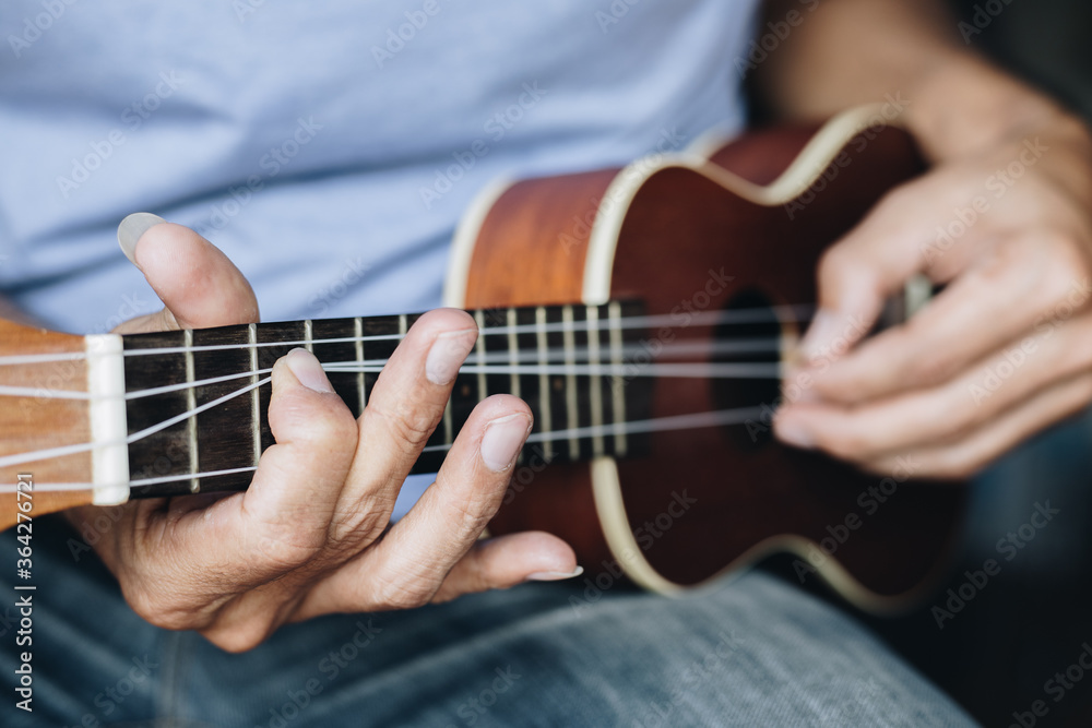 Close up Young man playing ukulele