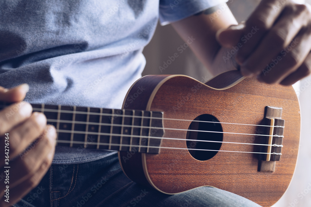 Fototapeta premium Close up Young man playing ukulele