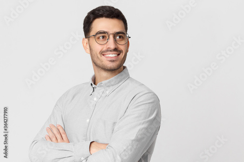 Young handsome business man dressed in casual denim shirt, isolated on gray background