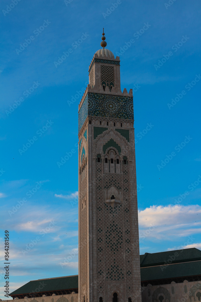 Hassan II mosque - the largest mosque of Morocco on the background of bright blue sky