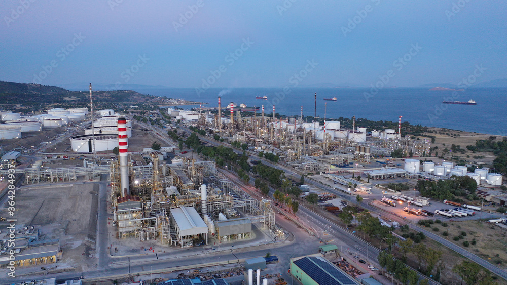 Aerial drone photo of industrial oil and gas plant in Corinth area overlooking Saronic gulf at dusk, Attica, Greece