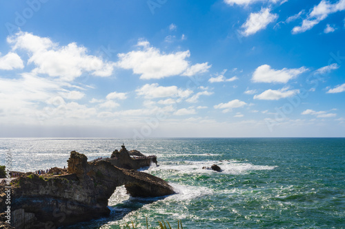 Seascape of Biarritz with rocks over the ocean, blue sky and white clouds. Basque Country of France.