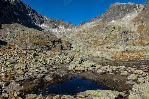 Lake in mountains. Pond in Valley of Five Spis Lakes surrounded by rocky summits, High Tatra Mountains, Slovakia.