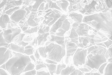 Closeup of desaturated transparent clear calm water surface texture with splashes and bubbles. Trendy abstract nature background. White-grey water waves in sunlight