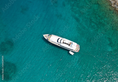 Aerial drone photo of yacht - boat with wooden deck anchored in tropical exotic paradise with turquoise open sea