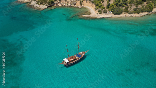 Aerial drone photo of beautiful wooden deck classic sailing yacht cruising in open ocean deep blue sea