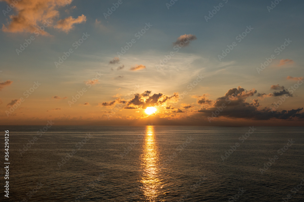 Golden sunrise or sunset on the sea, over which hung a big clouds and the sky is beautiful quiet atmosphere feeling lonely