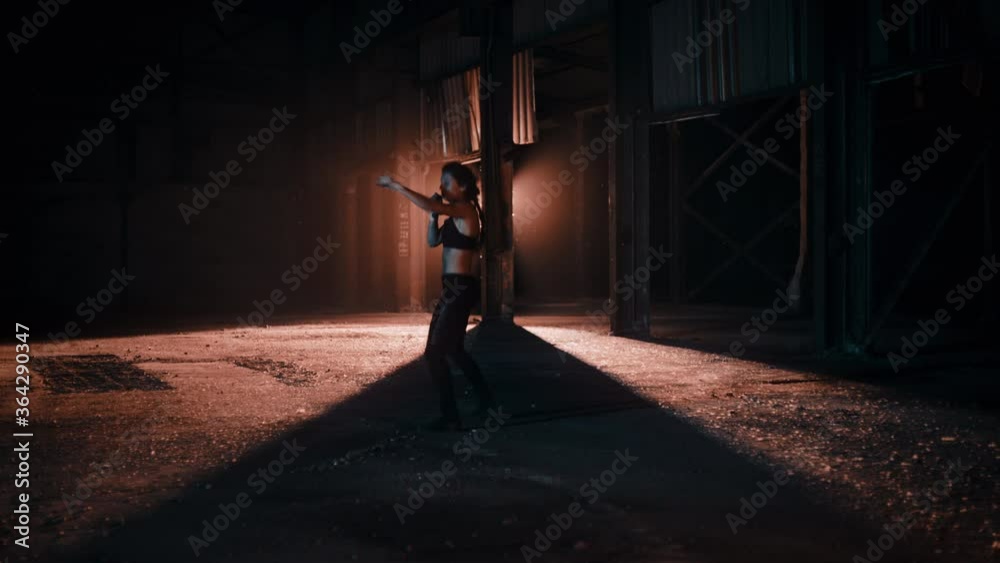 Woman training while kicking and punching Woman training while kicking and punching