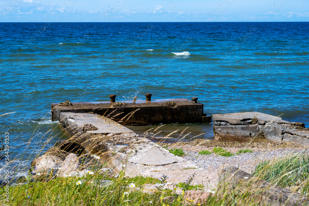 Old concrete pier next to beach and ocean at island of Gotland in Sweden
