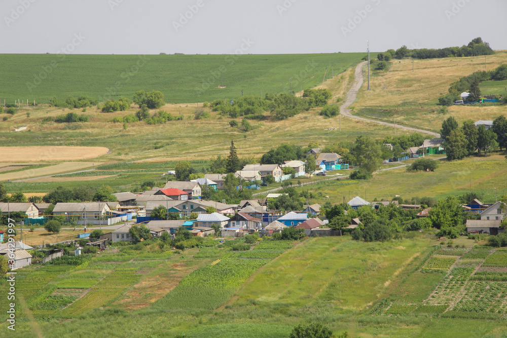 Obraz premium Beautiful view of a Russian village from the hill. Lovely little houses.
