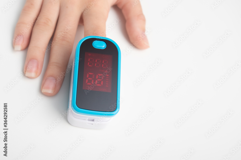 An essential medical device for hypoxia. Female finger in a pulse oximeter An essential medical device for hypoxia. Female finger in a pulse oximeter