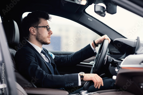 Young business man driving alone in his new car © Prostock-studio