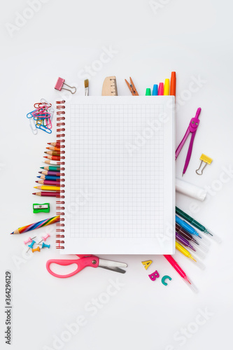 Blank squared notebook on colorful school supplies