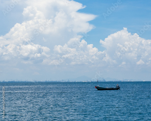Wallpaper Mural A man sits on a boat and fishing in the sea under blue sky with cloud. Torontodigital.ca