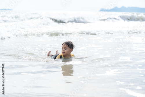 Portrait of little boy splashing in ocean waves