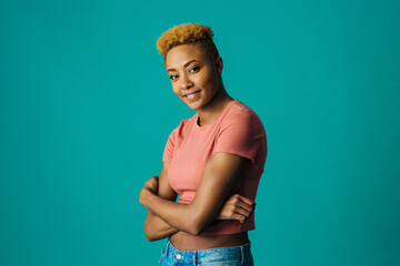 Portrait of a smiling young female with cool short hair  and arms crossed