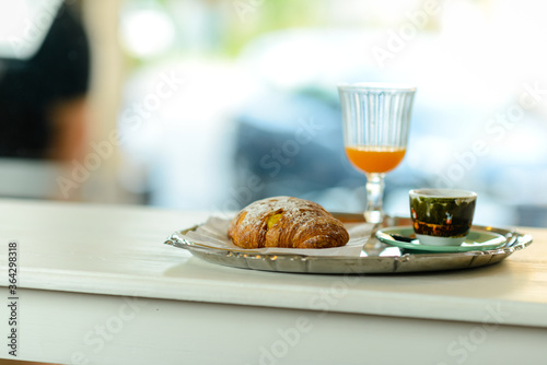 Espresso coffee, orange juice.  and custard pastry cream croissant for a caloric breakfast or coffee break, selective focus. bokeh, shallow dof photo