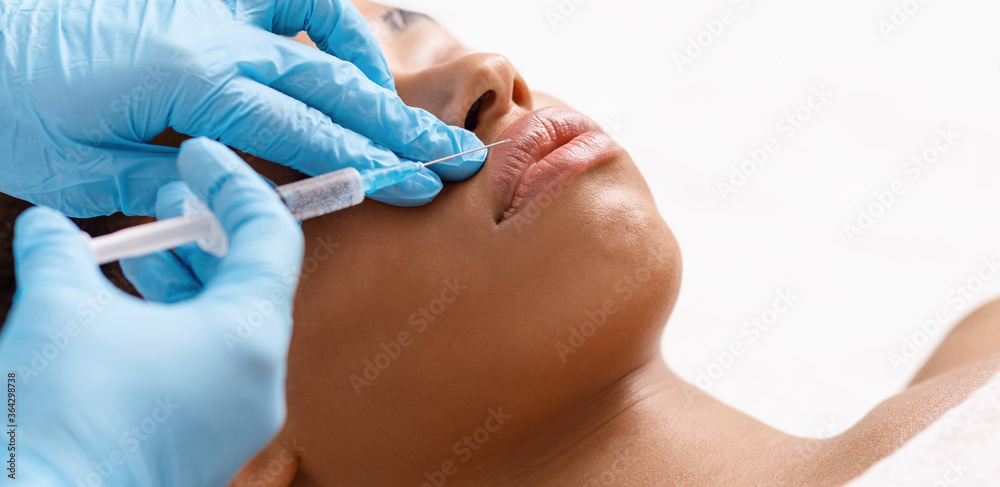 Young black woman receiving beauty injection at spa salon