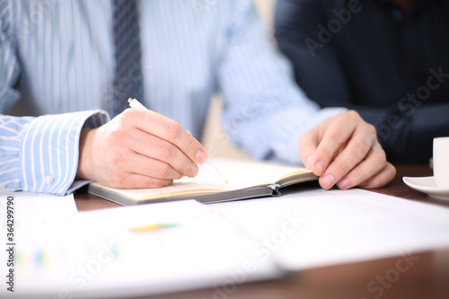 business people and lawyers discussing contract papers sitting at the table. Concepts of law, advice, legal services. © Tony Alexson