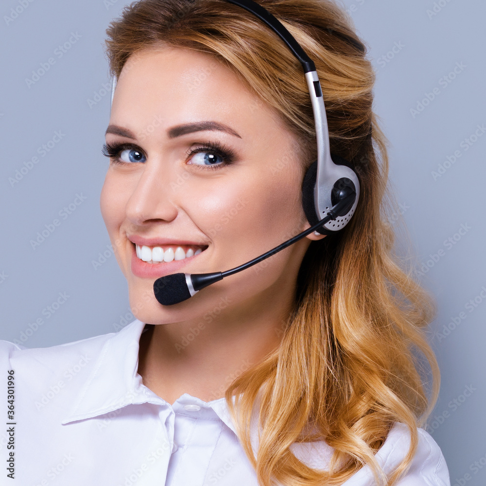 Closeup face portrait image of support phone operator in headset, against grey color background. Consulting and assistance service call center. Square composition picture. Closeup face portrait image of support phone operator in headset, against grey color background. Consulting and assistance service call center. Square composition picture.