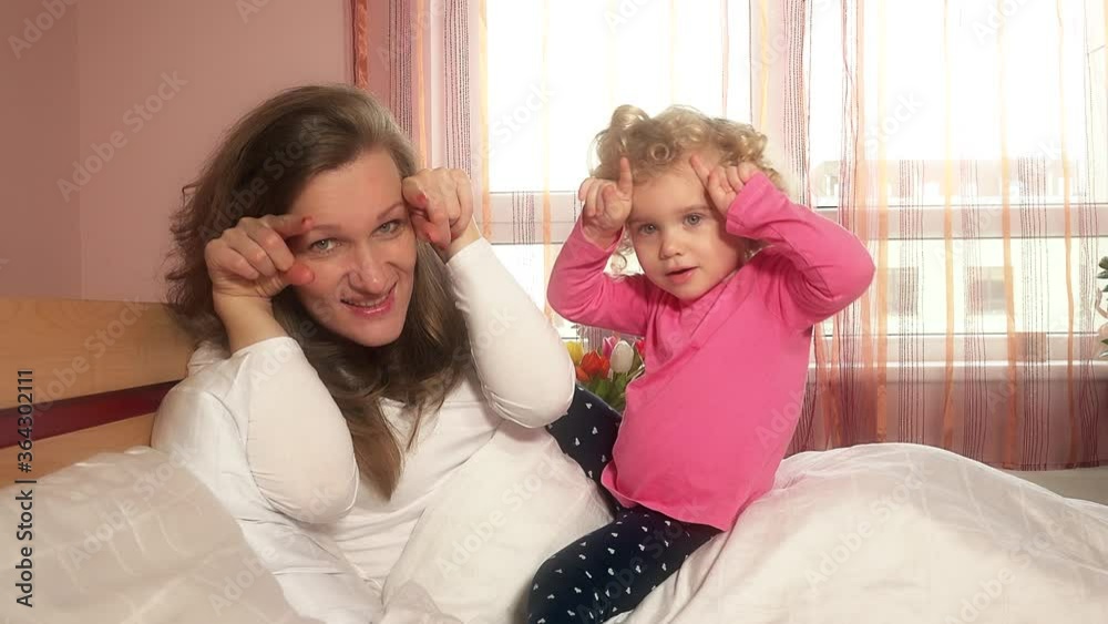 mother play with her little curly daughter in bed. 4K mother play with her little curly daughter in bed. 4K