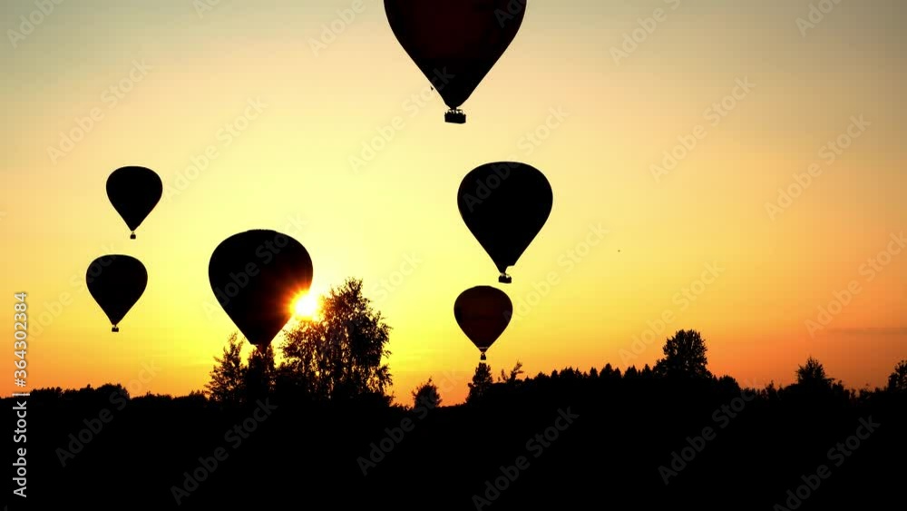 Hot air balloons landing over amazing sunset sun light. Dramatic color grading Hot air balloons landing over amazing sunset sun light. Dramatic color grading