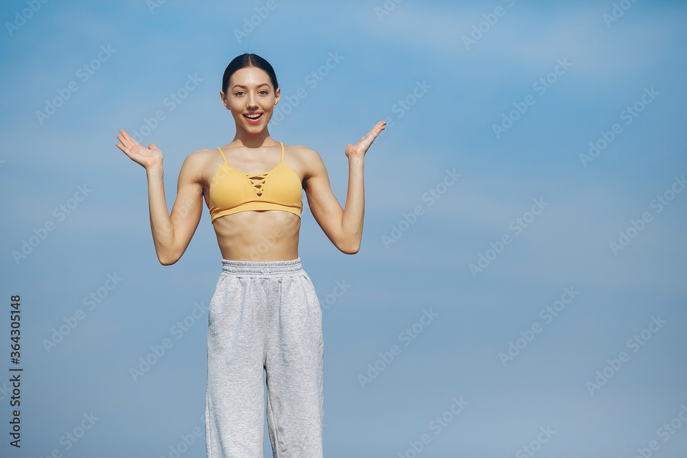Beautiful girl training on a sky background. Woman in a yellow top. Lady make a yoga Beautiful girl training on a sky background. Woman in a yellow top. Lady make a yoga