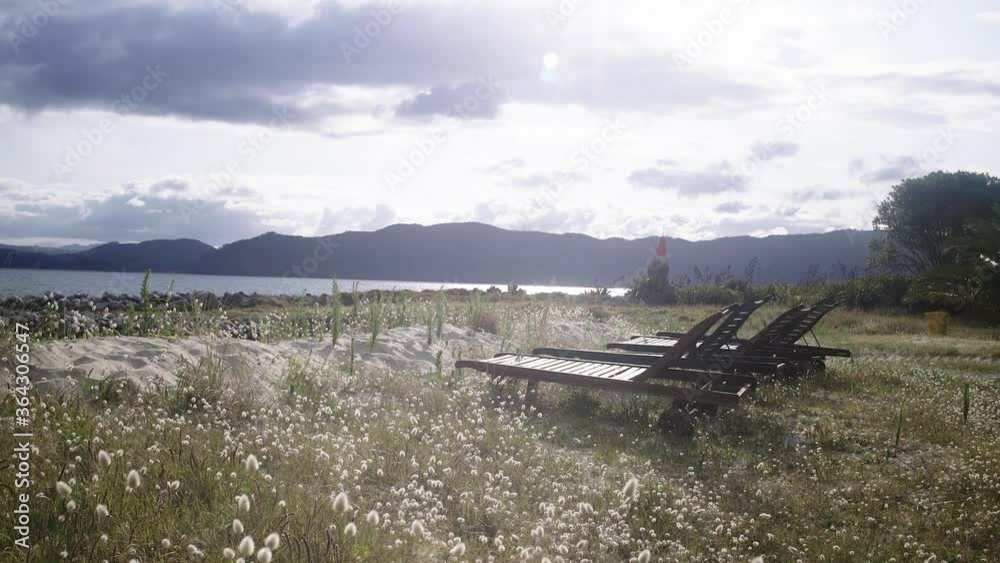 sun lounger by the beach with beautiful sun and grass golden hour.mov