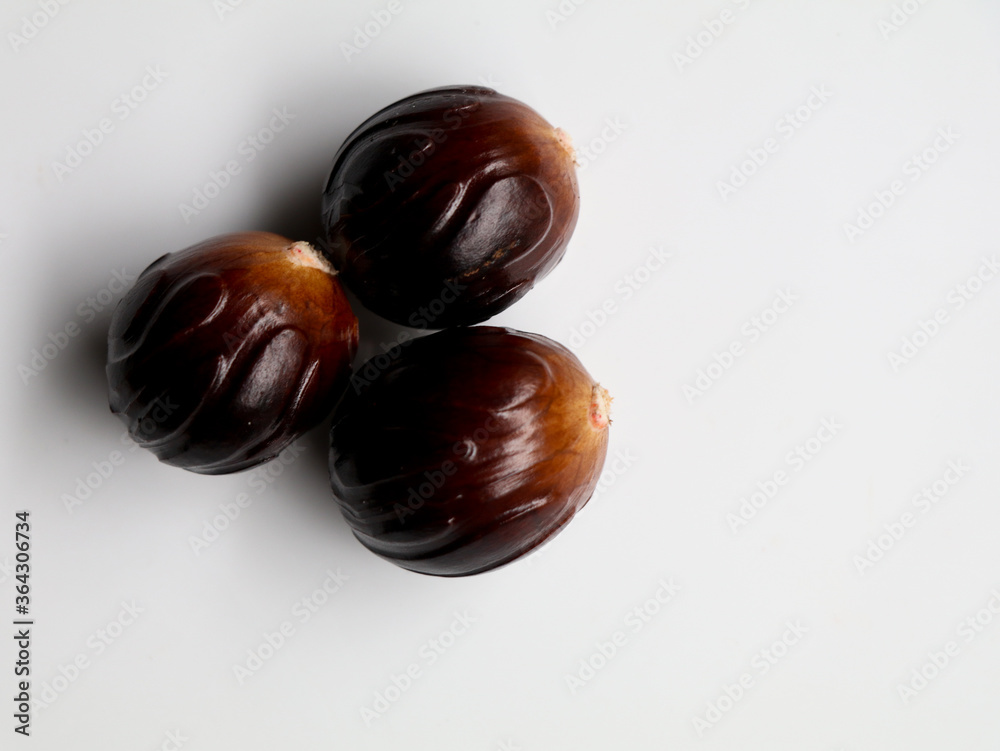 Obraz premium Fresh brown color nutmeg seed kept against white background