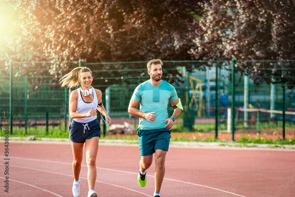 Beautiful young couple running outdoors while smiling