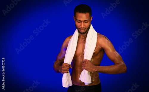 Muscular Guy Holding Towel Posing In Studio Over Blue Background