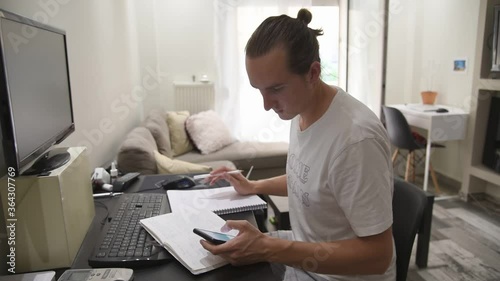 Man sitting at the office at home, taking notes while working from home. photo