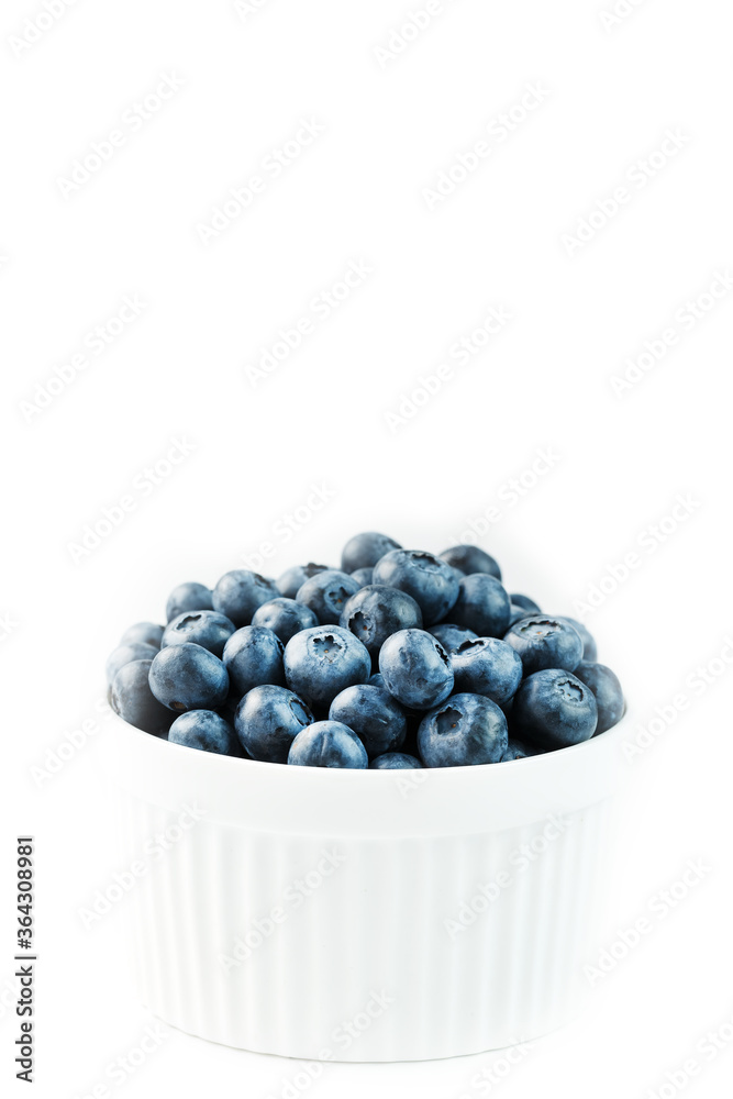 Blueberries are ripe berries in a white Cup on a white background. Blueberries are ripe berries in a white Cup on a white background.