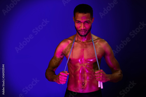 Muscular Man Posing With Jump Rope Standing In Studio