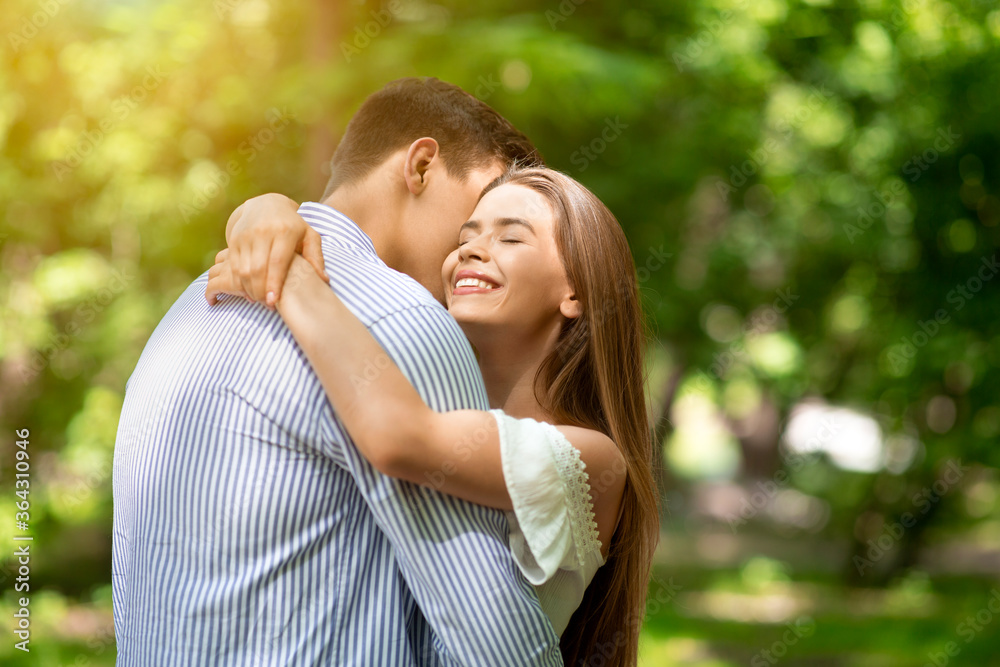 Tender couple embracing, bonding to each other at summer park on sunny day. Blank space Tender couple embracing, bonding to each other at summer park on sunny day. Blank space