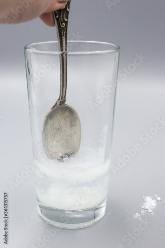 Transparent glass glass with water and white sorbent powder for treatment, ingestion for poisoning, allergies. The dissolution of the sorbent in the water. photo