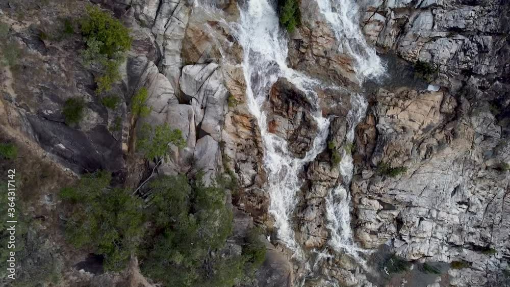 Aerial Top Down View Of Emerald Creek Falls With Water Cascading Down Rock Face. Follow Shot