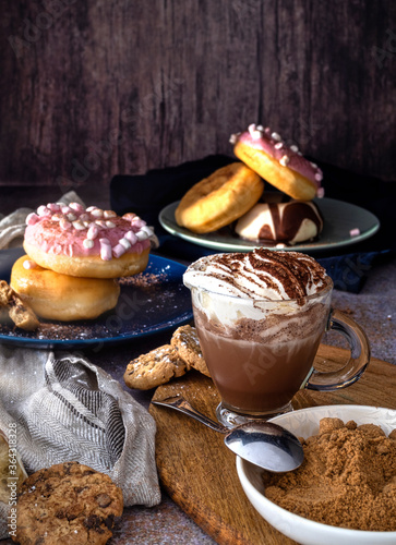 Colored doughnuts with different coverings. Cup of chocolate with cream. photo