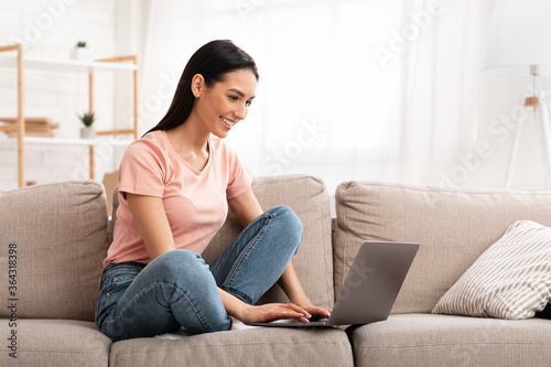 Free Download Woman using laptop phone sitting on sofa - GFXLoad